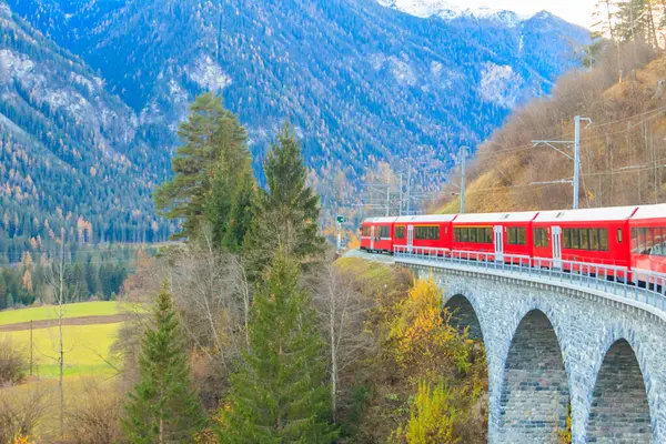 stock image Red passenger train on Rhaetian railway in Canton Graubunden, Switzerland at autumn