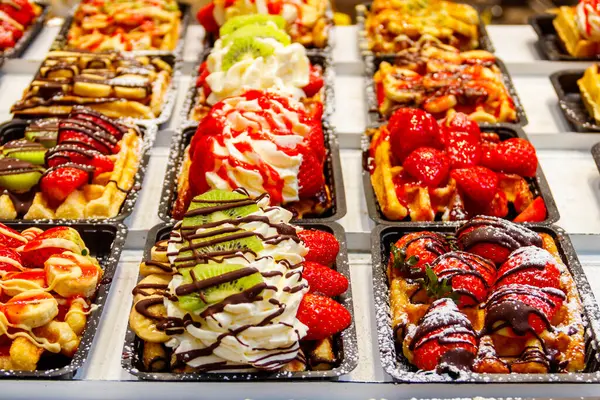 Brüksel, Belçika 'da renkli tatlı soslu Belçika waffleları ve satılık meyveler
