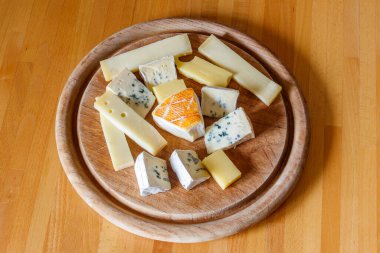 Tahta masada farklı peynirler bulunan peynir tabağı.