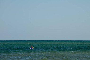 Genichesk, Ukrayna - 25 Ağustos 2017: İnsanlar pedallı tekneyle suda kayarak denize iniyor