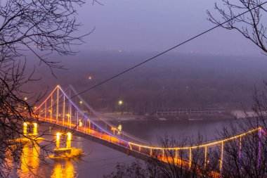 View on the pedestrian bridge across the Dnieper river at night. Kiev city, Ukraine