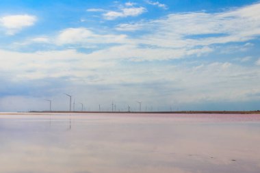 Wind turbines on a shore of the pink salty Syvash lake in Kherson region, Ukraine. Renewable energy clipart