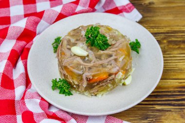 Meat aspic in a plate on a wooden table. Traditional russian dish clipart