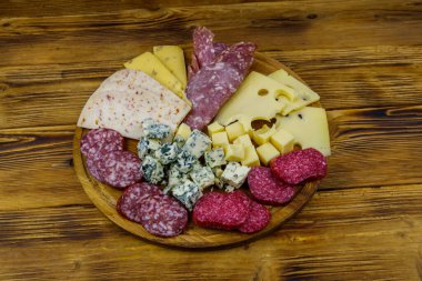 Tahta masada İtalyan salam ve peynirinden oluşan antipasti tabağı.