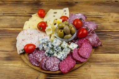 Zeytinli, kiraz domatesli, ahşap bir masada İtalyan salamı ve peyniri karışımı.