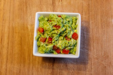 Tahta bir masada bir kase guacamole.