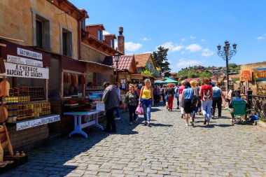 Mtskheta, Gürcistan - 1 Mayıs 2018: Gürcistan 'ın en eski şehirlerinden biri olan ve Dünya Mirası Alanı olarak belirlenen tarihi Mtskheta kentindeki hediyelik eşya dükkanlarıyla sokakta yürüyen turistler