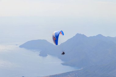 Türkiye 'nin Antalya ilinin Kemer ilçesi yakınlarındaki Tahtali dağının tepesinden paraşütçüler uçuyor. Aktif yaşam tarzı ve ekstrem spor macerası kavramı