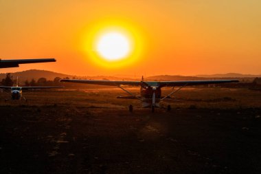 Arusha Havaalanı, Tanzanya 'da gün batımında küçük pervaneli uçaklar