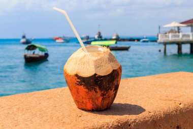 Stone Town, Zanzibar, Tanzanya 'da okyanus kenarında pipet içilen taze tropikal hindistan cevizi kokteyli.