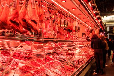 Barcelona, İspanya - 17 Aralık 2022: İspanya 'nın Barcelona şehrinin en popüler turistik beldelerinden biri olan La Boqueria pazarında satılık sosis ve jamon