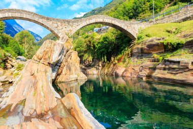 Lavertezzo, Verzasca Vadisi, Ticino Kantonu, İsviçre 'deki Verzasca nehrinin temiz suları üzerinde antik çift kemerli Roma köprüsü (Ponte dei Salti)