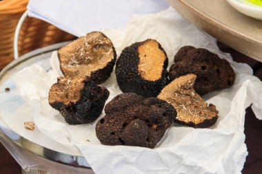 Masadaki tabakta pahalı siyah trüf mantarları.