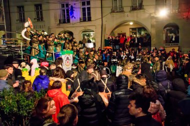 Bern, İsviçre - 24 Şubat 2023: Guggenmusik grubu, İsviçre 'nin Bern kentinde düzenlenen karnaval kapsamında, kalabalığa kostüm giydirme oyunu