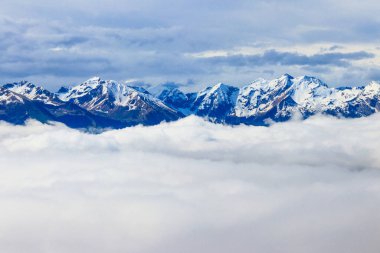 Bernese Oberland, İsviçre 'deki kalın bulutların üzerindeki kar kaplı dağların güzel manzarası.