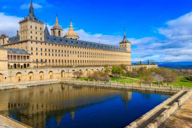 Güzel El Escorial, ya da San Lorenzo de El Escorial Kraliyet Sitesi, ya da bahçeli ve göldeki yansımaları olan Manastır de El Escorial. İspanya 'da Madrid yakınlarındaki ünlü kralların evi.