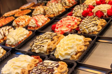 Brüksel, Belçika 'da renkli tatlı soslu Belçika waffleları ve satılık meyveler