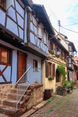 Street with picturesque colorful half-timbered houses in the medieval village of Eguisheim, Alsace, France. Village is ranked in the top 20 of Les Plus Beaux Villages de France. Alsace wine route clipart