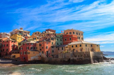 İtalya 'nın Cenova kentindeki Boccadasse eski balıkçı köyünün kumsal, mavi deniz ve renkli binalarının manzarası.