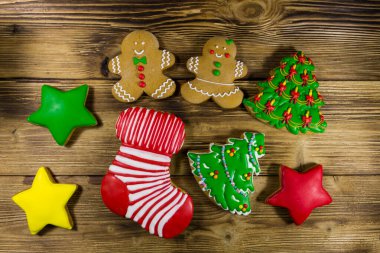 Noel ağacı şeklinde lezzetli Noel kurabiyeleri, zencefilli kurabiye adam, yıldız ve ahşap masada Noel çorabı. Üst görünüm