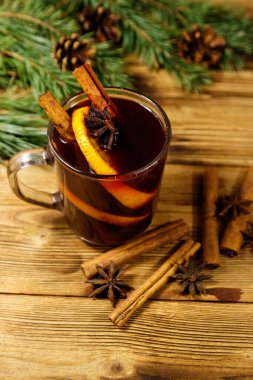 Noel şarabı baharatlar ve köknar ağacı dalları ve kozalaklar ahşap masada.