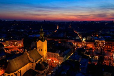 Ukrayna, Lviv 'deki Aydınlatılmış Latin Katedrali ve Rynok Meydanı' nın gece görüşü. Lviv belediye binasından görüntü