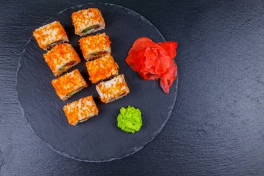 Suşi Philadelphia 'yı siyah bir levhada yuvarlıyor. Üst görünüm