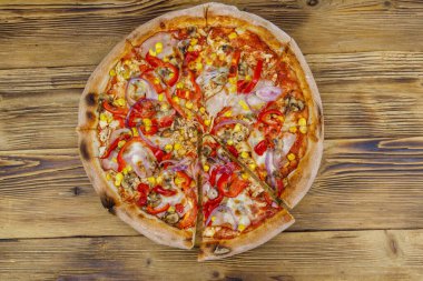 Tahta bir masada nefis taze pizza. Üst görünüm