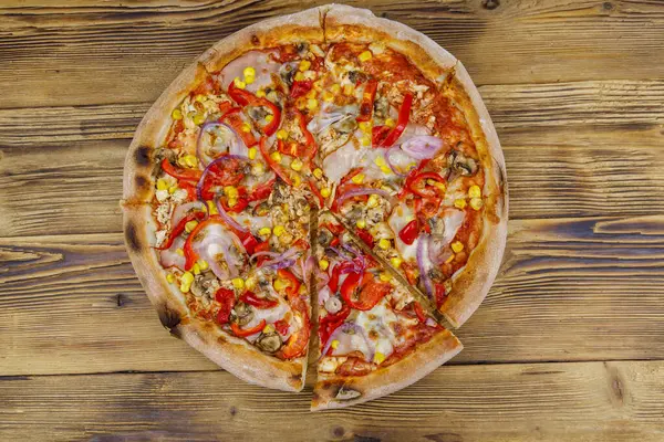 Tahta bir masada nefis taze pizza. Üst görünüm