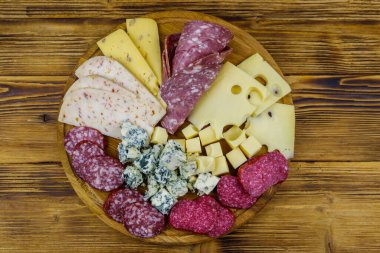 Tahta masada İtalyan salam ve peynirinden oluşan antipasti tabağı. Üst görünüm