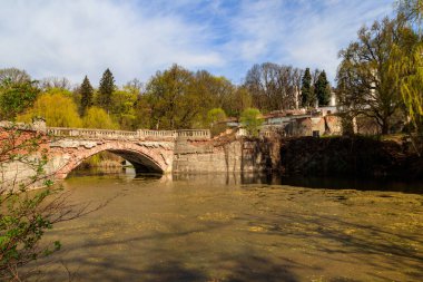 Ukrayna 'nın Kharkov bölgesindeki Sharovka Sarayı parkındaki bir gölette eski kemerli tuğla köprü.