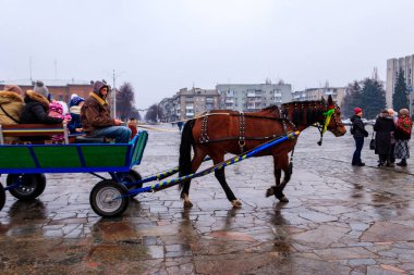 Kremenchug, Ukrayna - 17 Şubat 2018: Meçhul insanlar Maslenitsa kutlamaları sırasında şehir parkında at arabasına biniyorlar