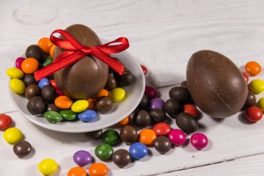 Beyaz ahşap arka planda çikolata yumurtalı Paskalya kompozisyonu