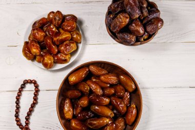 Beyaz ahşap masada meyve ve tespihle çıkıyor. Üst Manzara. Müslümanların kutsal Ramazan bayramı