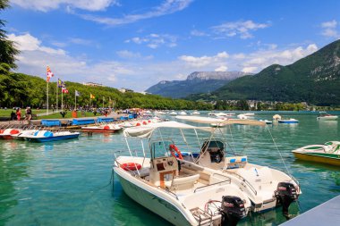 Annecy, Fransa - 16 Mayıs 2022: Annecy Gölü 'ndeki botlar ve pedallar Fransa' nın Annecy kentindeki güzel dağlarla çevrili