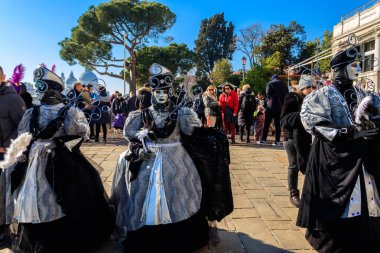 Venedik, İtalya - 12 Şubat 2023: Venedik, İtalya 'da düzenlenen yıllık Venedik Karnavalı sırasında kimliği belirsiz insanlar renkli maskeler ve kostümler giyiyorlar