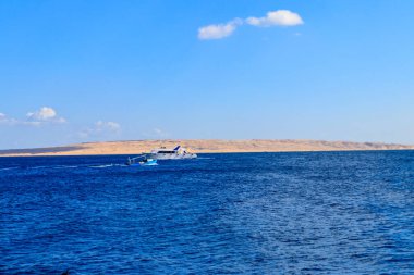Eski balıkçı teknesi ve beyaz lüks yat Kızıldeniz, Mısır yelken