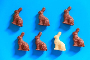 Mavi arka planda Paskalya çikolatalı tavşanları. Üst görünüm