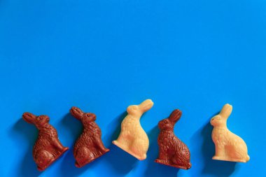 Mavi arka planda Paskalya çikolatalı tavşanları. Üst görünüm