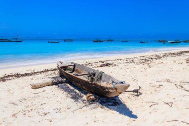 Tanzanya, Zanzibar 'daki Hint Okyanusu' ndaki tropikal kumlu Nungwi sahilinde eski ahşap bir tekne kıyıya vurmuş.