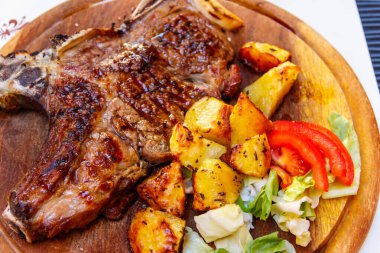 Kızarmış domuz bifteği, patates ve sebzeli kemik.