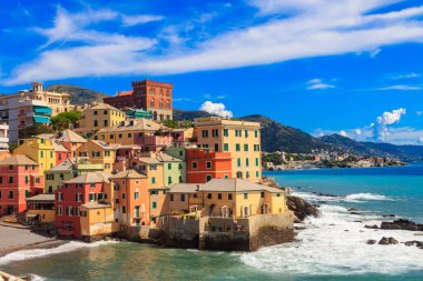 İtalya 'nın Cenova kentindeki Boccadasse eski balıkçı köyünün kumsal, mavi deniz ve renkli binalarının manzarası.