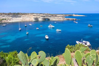Delimara yarımadasının güzel kıyı manzarası. Malta 'da kayalar ve turkuaz deniz yatları var.
