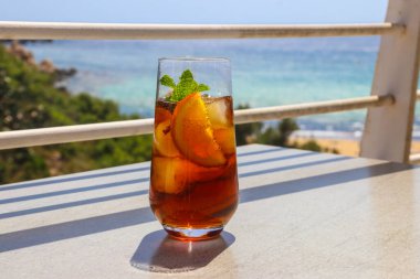 Deniz manzaralı bir masada tropik bir kokteyl.
