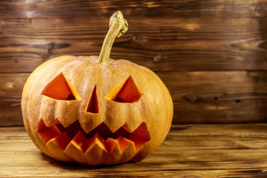 Ahşap bir arka planda ürkütücü Cadılar Bayramı balkabağı kabağı kabağı kabağı.