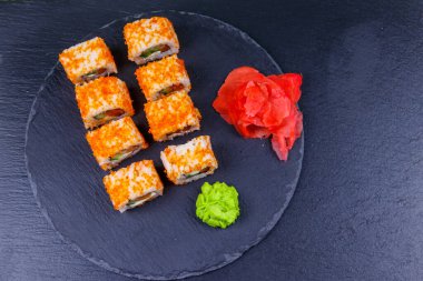 Suşi Philadelphia 'yı siyah bir levhada yuvarlıyor. Üst görünüm
