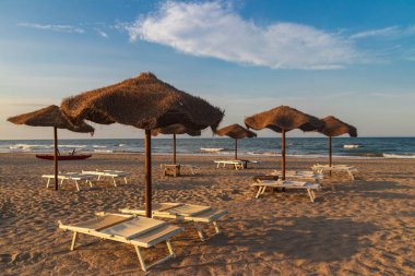 Tropik plajlarda güneş şemsiyeleri ve şezlonglar. Dinlenme, rahatlama, tatil, tatil
