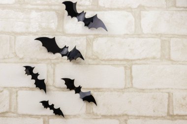 Beyaz tuğlalı duvarda yarasalar. Cadılar Bayramı partisi için dekorasyon. Boşluğu kopyala