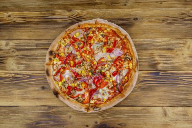 Tahta bir masada nefis taze pizza. Üst görünüm