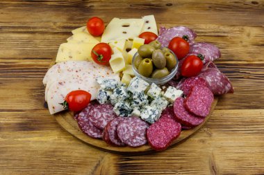 Zeytinli, kiraz domatesli, ahşap bir masada İtalyan salamı ve peyniri karışımı.